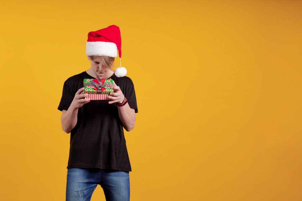 A teenage boy holding a Christmas present